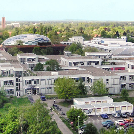 Picture from the File:Freie Universitaet Berlin - Gebaeudekomplex Rost-  campus. The image shows the campus big university, built in the 20th century, with a lot of trees. The pictures is from wikimedia common, in particular this link https://commons.wikimedia.org/wiki/File:Freie_Universitaet_Berlin_-_Gebaeudekomplex_Rost-_und_Silberlaube.jpg. 